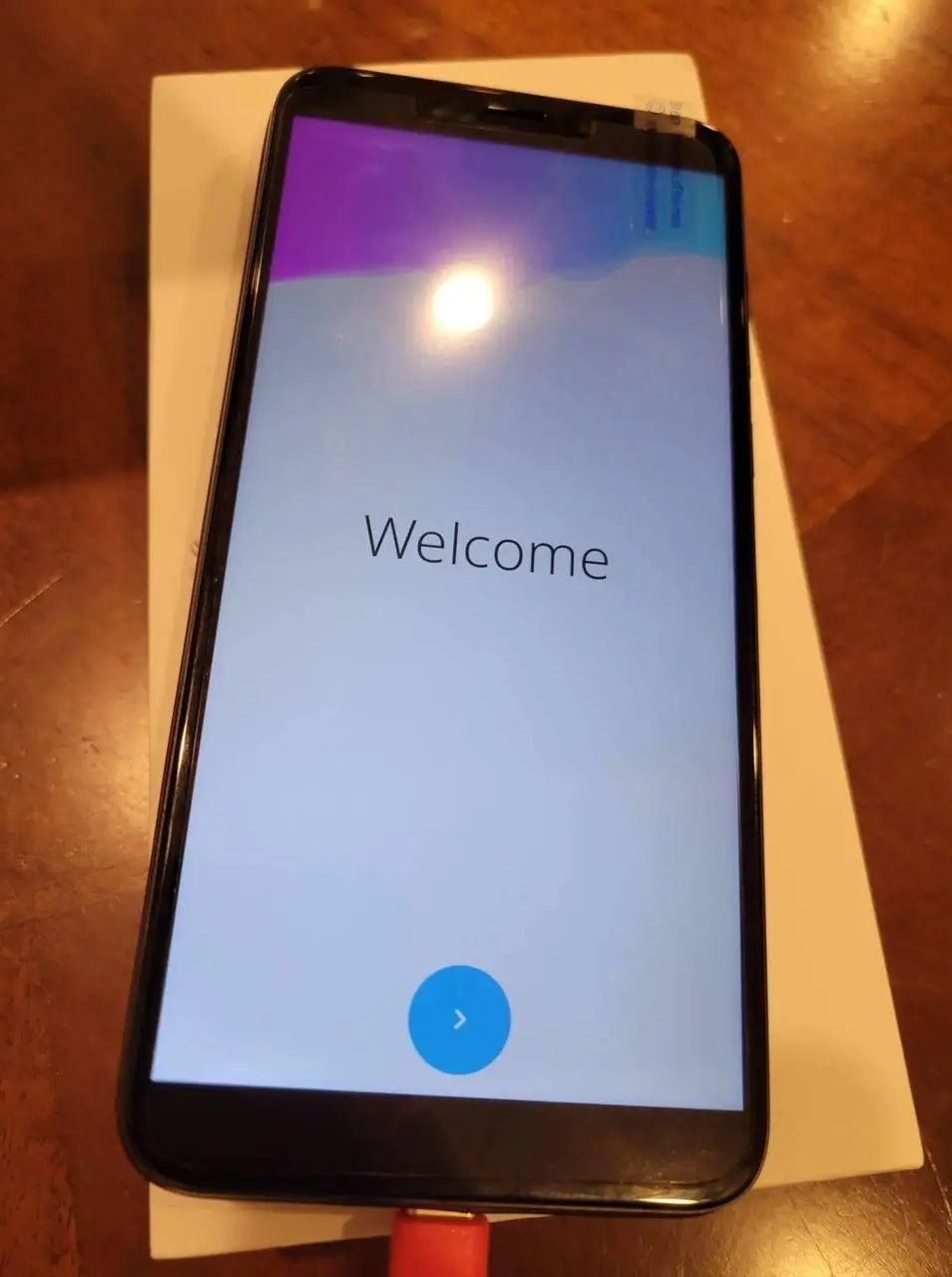 A PinePhone showing the Plasma Mobile welcome screen.